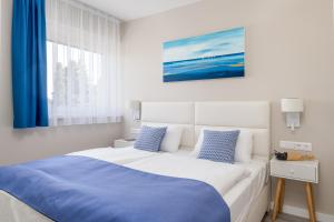 sypialnia z dużym łóżkiem i niebieskim kocem w obiekcie Lake Spirit Boutique Apartments w mieście Balatonalmádi +37 zdjęć