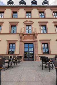 un bâtiment avec des tables et des chaises devant lui dans l'établissement DEINHARD's, à Bernkastel-Kues