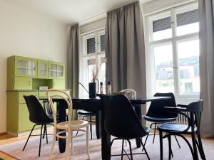 ein Esszimmer mit einem schwarzen Tisch und Stühlen in der Unterkunft Stadtjuwel mit Pfänderblick in Bregenz