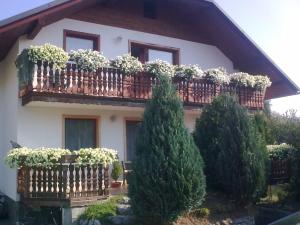 una casa con balcone con piante in vaso di Apartmaji Sparakel a Bled