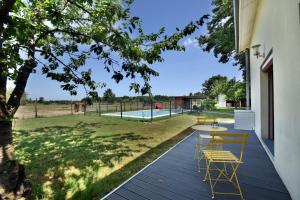 a deck with a table and chairs and a pool at Villa Monplaisir 82 in Montech