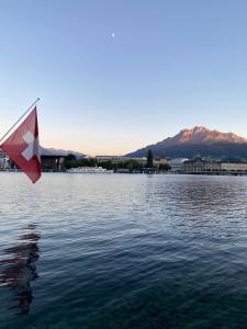 a red and white kite flying over a body of water at Apartment auf dem Bauernhof in Luzern
