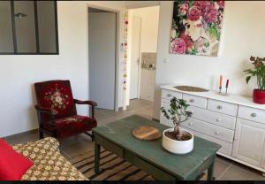 een woonkamer met een tafel en een stoel bij Gîtes Violettes et Amandier in Violès