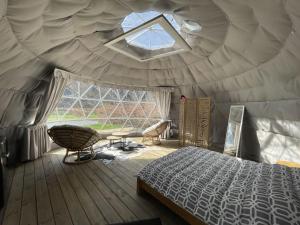 sypialnia z łóżkiem i oknem w namiocie w obiekcie ARDENNE CAMPING MABOGE w La-Roche-en-Ardenne