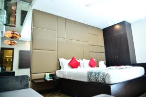 a bedroom with a large bed with red pillows at The Presidency in Bhubaneshwar