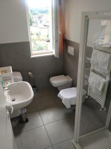 baño con lavabo y aseo y ventana en Appartamento Eleonora, en Muscoline