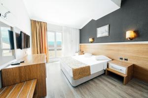a hotel room with a bed and a television at AFYTOS ÖREN PARK MTK in Burhaniye
