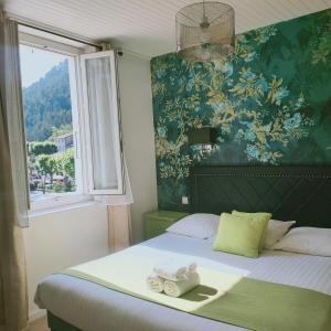 una camera da letto con un letto e asciugamani di Hotel du Levant a Castellane