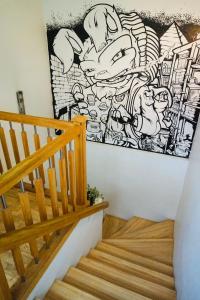un escalier avec une fresque murale représentant des dessins animés dans l'établissement Jimmy Jumps House, à Vilnius
