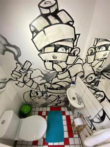 Baño con una pintura en la pared en Jimmy Jumps House en Vilna