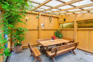 a patio with a wooden table and benches at Po Jūros Banga in Palanga