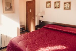 ペスカッセーロリにあるAlbergo il Plistiaの赤いベッド1台(赤い掛け布団付)が備わるベッドルームです。
