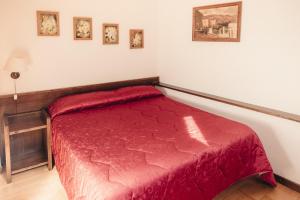 a bedroom with a red bed in a room at Albergo il Plistia in Pescasseroli