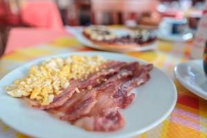 a plate of food with bacon and corn on a table at Bed and Breakfast Cairoli Exclusive Room in San Pietro Vernotico