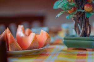 un piatto di frutta su un tavolo con una pianta di Bed and Breakfast Cairoli Exclusive Room a San Pietro Vernotico