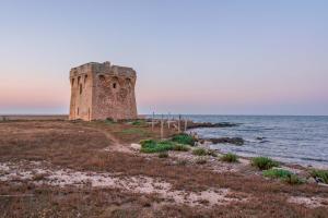 una vieja torre en la orilla del océano en Bed and Breakfast Cairoli Exclusive Room, en San Pietro Vernotico