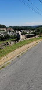 an empty road next to a field with a rock at la petite chambre in Felletin