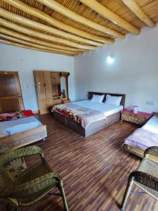 1 dormitorio con 2 camas y 2 sillas en Nilza Guest House, en Leh