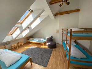 a attic room with bunk beds and a couch at Jimmy Jumps House in Vilnius