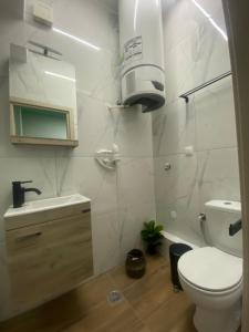 Baño blanco con aseo y lavamanos en Treasure box apartment _Aristotelous square_, en Tesalónica