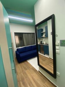 espejo en una habitación con sofá azul en Treasure box apartment _Aristotelous square_, en Tesalónica