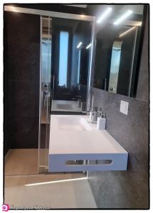 La salle de bains est pourvue d'un lavabo blanc et d'un miroir. dans l'établissement Alta Area, à Nova Siri