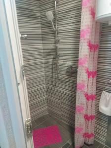een badkamer met een douche en een roze douchegordijn bij Orhideja Visoko in Visoko