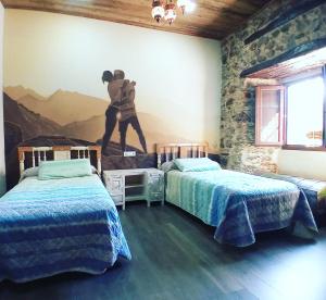 a room with two beds and a mural of a man on the wall at Hostal La Medina de Camponaraya in Camponaraya