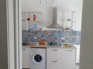 a kitchen with a washer and a washing machine at Sabbia d'oro in Santa Maria Del Focallo