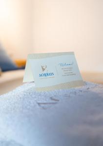 a card sitting on top of a bed at Dorkas Luxury Rooms&Apartments in Livadakia