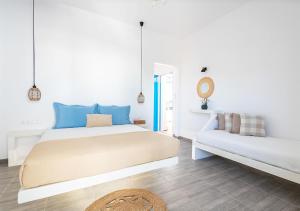 a white bedroom with a bed and a couch at Dorkas Luxury Rooms&Apartments in Livadakia