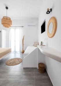 a white living room with a sink and a mirror at Dorkas Luxury Rooms&Apartments in Livadakia