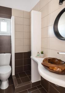 a bathroom with a toilet and a sink at Dorkas Luxury Rooms&Apartments in Livadakia
