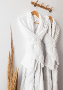 a group of white towels hanging on a wall at Dorkas Luxury Rooms&Apartments in Livadakia