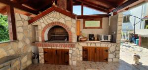 an outdoor kitchen with a stone oven in a house at Apartments Alicia Lopar-50m vom Strand in Lopar +17 photos