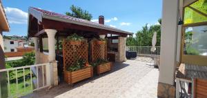 a gazebo with potted plants on a patio at Apartments Alicia Lopar-50m vom Strand in Lopar