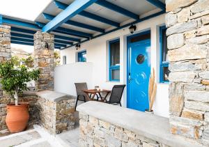 a patio with a blue door and a table at Dorkas Luxury Rooms&Apartments in Livadakia