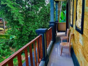 une véranda avec deux chaises et un arbre dans l'établissement Ubud home stay, à Gianyar