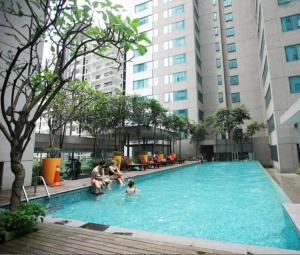 a group of people in a swimming pool in a building at Summer Suites Apartment @KLCC by Sarah's Lodge in Kuala Lumpur