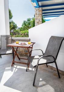 a wooden table and a chair on a patio at Dorkas Luxury Rooms&Apartments in Livadakia