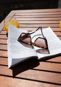 a pair of glasses sitting on a book on a table at Dorkas Luxury Rooms&Apartments in Livadakia