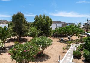 a garden with trees and bushes and flowers at Dorkas Luxury Rooms&Apartments in Livadakia