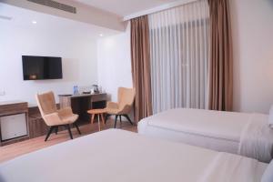 Un pat sau paturi într-o cameră la Elmos Hotel