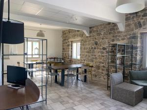 a room with tables and chairs and a stone wall at Alta Area in Nova Siri