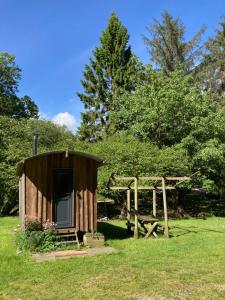 a small wooden shed in a field of grass at Swaledale Shepherd's Hut in Newton Abbot