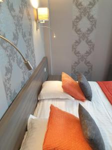 two beds with pillows on them in a room at Hôtel Le Rohan Charme et Caractère in Pontivy