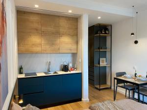 a kitchen with blue cabinets and a dining table at VilaA21 in Bar