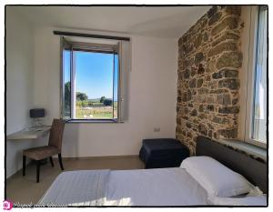 ein Schlafzimmer mit einem Bett und einer Steinmauer in der Unterkunft Alta Area in Nova Siri