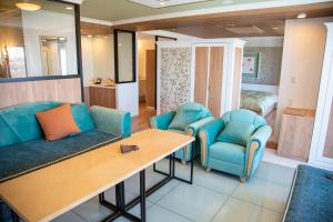 ein Wohnzimmer mit 2 blauen Stühlen und einem Tisch in der Unterkunft Shiretoko Daiichi Hotel in Shari