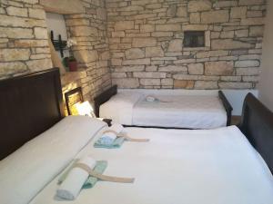 - 2 lits dans une chambre avec un mur en pierre dans l'établissement Little App - magical surrounding, à Sveti Petar u Šumi